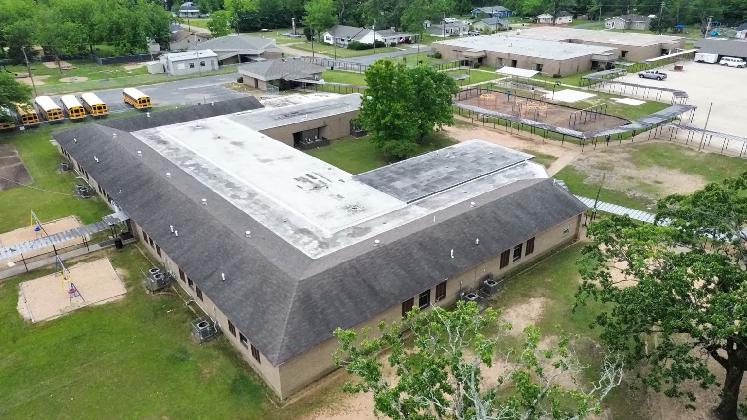 Wide aerial inspection view of a large commercial roof system